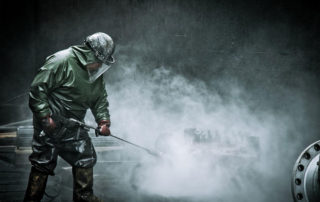 An employee professionally pressure washes mechanical equipment in WA