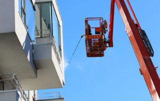An employee professionally pressure washes an apartment building in WA